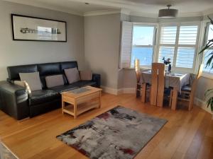 a living room with a black couch and a table at Direct Sea Views Seafront Location & Free Parking in Brighton & Hove