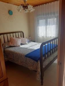um quarto com uma cama com lençóis azuis e uma janela em Casa Valeriana Guijosa em Guijosa