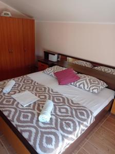 a bedroom with a large bed with two pillows on it at Apartman Mia Mare in Kraj