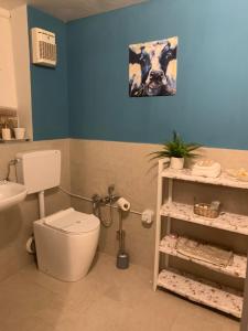 a bathroom with a toilet and a picture of a cow at Fattoria Amelia in Santa Caterina