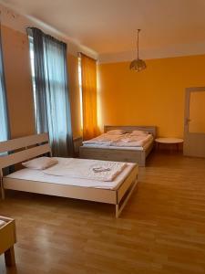 2 camas en una habitación grande con paredes amarillas en Hotel Praha Club bed & breakfast, en Praga