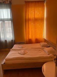 een slaapkamer met een groot bed met witte lakens en een raam bij Hotel Praha Club bed & breakfast in Praag