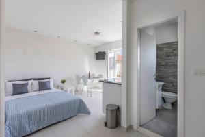 una camera bianca con letto e bagno di Apartment Anna - 20 m from the sea a Postira (Postire)