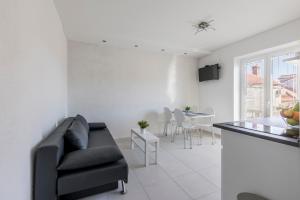 a living room with a black couch and a table at Apartment Anna - 20 m from the sea in Postira