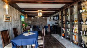a dining room with a blue table and some bottles of wine at Vila Vista Вила Виста in Sveti Vlas