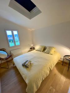 a bedroom with a large white bed with two pillows at Maison spacieuse à deux pas de la plage … in Le Palais