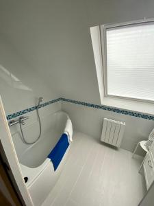 ein Bad mit einer Badewanne und einem Fenster in der Unterkunft Maison spacieuse à deux pas de la plage … in Le Palais