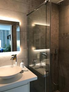 a bathroom with a glass shower and a sink at Au Calme in Sint-Genesius-Rode