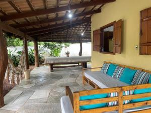 a patio with a couch and a table and a bench at chacara sombra da mata01 in Pirenópolis