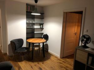 ein Zimmer mit einem Tisch, Stühlen und einem Bücherregal in der Unterkunft Apartament na Okulickiego - Centrum !! in Stalowa Wola