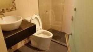 een badkamer met een wit toilet en een wastafel bij Hotel Sri Iskandar in Kota Kinabalu