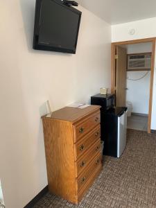 a room with a dresser and a television on a wall at HAVEN INN in Glendale