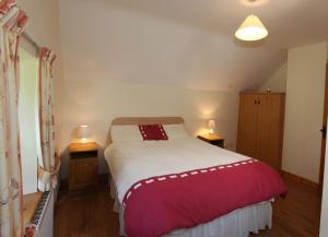 um quarto com uma cama com um cobertor vermelho e branco em John Joe's Self Catering em Blacklion