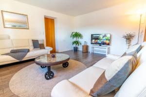 a living room with a couch and a table at Charmantes Apartment mit grossem Garten .Kids4free. in Flims