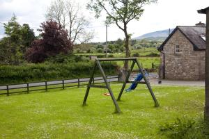 a swing set in the grass in a yard at John Joe's Self Catering in Blacklion