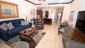 a living room with a blue couch and a table at Ground Floor Sonoran Sun 111-E - 1BR 1BA in Puerto Peñasco