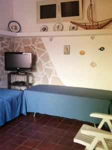 un salon avec un canapé bleu et une télévision dans l'établissement Home Beach Costa Rey, à Costa Rei