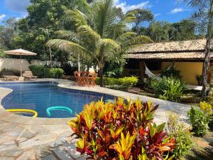 a resort with a swimming pool and palm trees at chacara sombra da mata01 in Pirenópolis