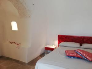 a bedroom with a bed with a red headboard at Fiore di Cappero in Ostuni