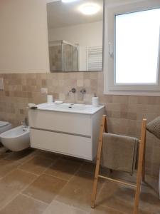 a bathroom with a sink and a tub and a mirror at Fiore di Cappero in Ostuni