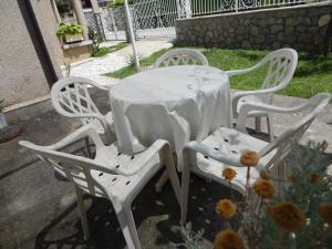 three white chairs and a table with a white table cloth at Luxury Apartment Biljana in Ohrid