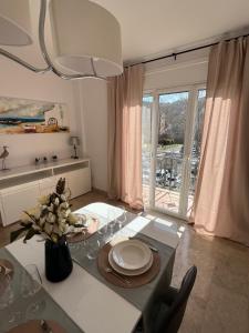 a dining room with a table with a vase of flowers at Apartamento luminoso Paloma a 350 metros de la playa con parking gratuito in Sant Feliu de Guixols