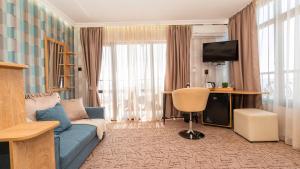 a living room with a blue couch and a television at Vila Vista Вила Виста in Sveti Vlas