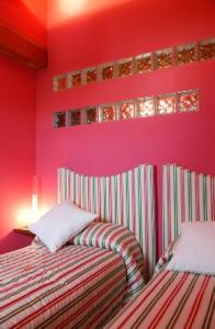 two beds in a room with pink walls at Villa Don Juan II in Segovia +37 photos