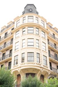 een hoog wit gebouw met een zwart dak bij Apartamento Royal in San Sebastian