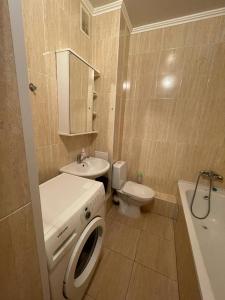 ein Badezimmer mit einer Waschmaschine und einem WC in der Unterkunft AK-BULAK TOWN Apart in Astana