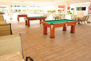 2 mesas de ping pong en una habitación con sillas en Lacqua diRoma Hotel com Parque Aquático 24 horas, en Caldas Novas