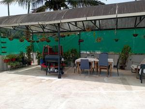 a patio with a table and chairs and a green wall at Mulberry Homestay in Thekkady