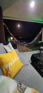 a bed with a yellow pillow and a hammock at Pé na areia Itacimirim in Camacari +29 photos