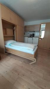 ein großes Bett in einem Zimmer mit Küche in der Unterkunft 1-Zimmer-Apartment 1 im 1. Obergeschoss in Lübeck
