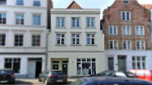 ein Gebäude in einer Stadtstraße mit vor der Tür geparkt in der Unterkunft 1-Zimmer-Apartment 1 im 1. Obergeschoss in Lübeck