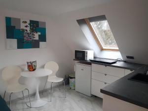 a small kitchen with a table and chairs and a window at Szöcske Guesthouse In the Danube Bend near Budapest in Szentendre