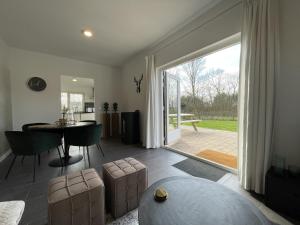 een woonkamer met een tafel en een eetkamer bij Vakantiehuis FijnDomein - vlak bij de Efteling in Dongen