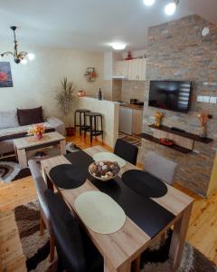 a living room with a dining table and a kitchen at Apartman Marija in Nova Varoš
