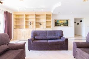 een woonkamer met een bank en 2 stoelen bij Apartamento Xixo in Benidorm