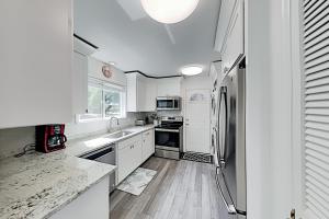 eine Küche mit weißen Schränken und einem Kühlschrank aus Edelstahl in der Unterkunft Lawson Road 10 in Hilton Head Island
