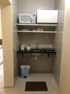 una pequeña cocina con fregadero y microondas en APARTAMENTO à 50 m do MAR - Praia de BOA VIAGEM, en Recife