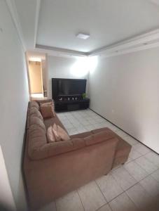 uma sala de estar com um sofá e uma televisão de ecrã plano em Sua casa fora de casa em Fortaleza