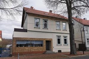 Casa blanca con techo rojo en Amys Ferienwohnungen Bad Harzburg en Bad Harzburg