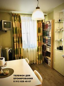a living room with a table and a book shelf at Apartment on Spasskaya 61 in Kirov