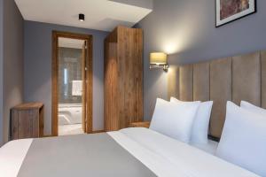 A bed or beds in a room at Barnovi Boutique Hotel
