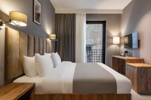 A bed or beds in a room at Barnovi Boutique Hotel