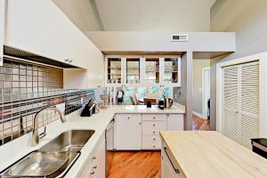 a large kitchen with white cabinets and a sink at Stones Way in Lake Forest Park