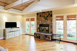 a living room with a stone fireplace and a tv at Stones Way in Lake Forest Park