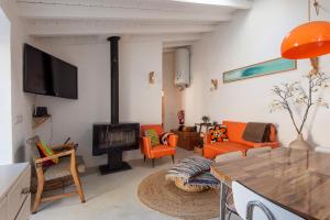 a living room with a fireplace and orange chairs at Hillside 1 Aljezur old town in Aljezur