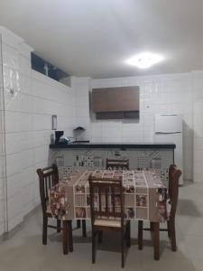 a kitchen with a table with four chairs and a kitchenventory at Casa Arraial do Cabo in Arraial do Cabo